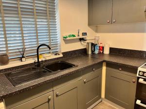 a kitchen with a sink and a counter top at Accessible Flat Bedford in Bedford
