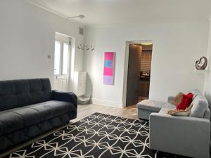 a living room with a couch and a chair at Accessible Flat Bedford in Bedford