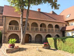 a large brick building with arches and a tree at Himmelswege in Nebra