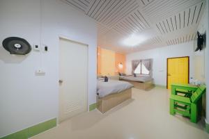 a bedroom with a bed and a yellow door in it at แฝดสามการ์เด้นท์รีสอร์ท แสมสาร Fadsarm Garden Resort Samaesan in Sattahip