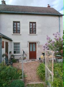 a white house with a red door at Maisonnette de village in Mosnes