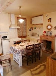 a kitchen with a table and chairs in a kitchen at Maisonnette de village in Mosnes