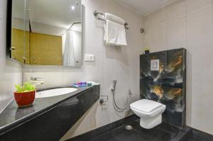 a bathroom with a sink and a toilet and a mirror at Hotel Mayur in New Delhi +16 photos