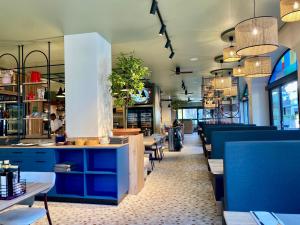 a restaurant with blue counters and tables and chairs at Casa Merano Residence & Restaurant Bibione Centro in Bibione