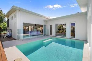 a swimming pool in the middle of a house at Palm Haven Coolum Beach in Coolum Beach