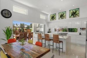a kitchen and dining room with a wooden table and chairs at Palm Haven Coolum Beach in Coolum Beach