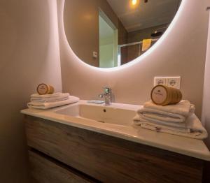 a bathroom with a sink with a mirror and towels at Kooparc in Giesbeek
