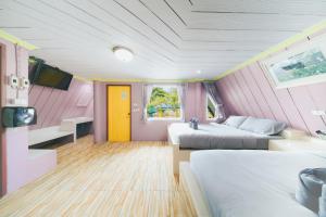 a bedroom with two beds and a yellow door at แฝดสามการ์เด้นท์รีสอร์ท แสมสาร Fadsarm Garden Resort Samaesan in Sattahip