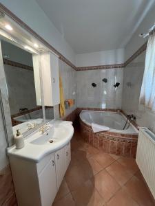a bathroom with a tub and a sink at Herczeg Villa in Balatongyörök +17 photos