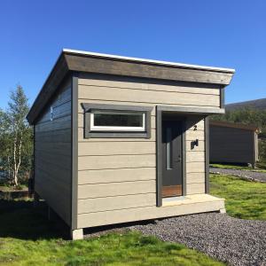 a small shed with a window in the grass at Enoks i Láddjujávri in Nikkaluokta