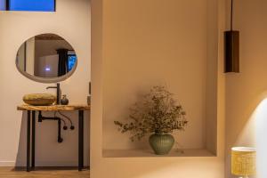 a bathroom with a mirror and a vase with a plant at Wellnesshoeve in Boutersem