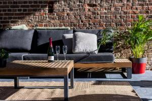 a bottle of wine sitting on a table next to a couch at Wellnesshoeve in Boutersem