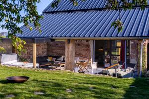 a brick house with a blue roof at Wellnesshoeve in Boutersem