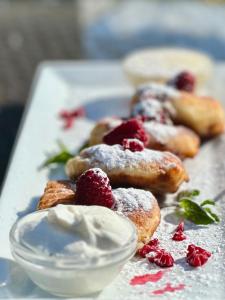 a plate of pastries with powdered sugar and raspberries at Центральна Садиба in Kryzhanivka