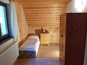 a bedroom with a bed and a dresser and a window at Chata Studnička in Jakubovany