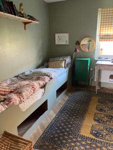a bedroom with two beds and a rug at Bra familjeboende Vitaby in Vitaby