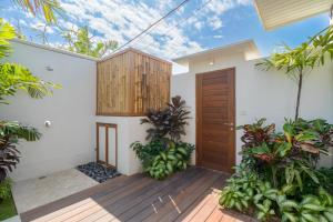 a house with a wooden door and some plants at Villa Lior - 1BR Luxury Hideaway near Nyanyi Beach in Canggu