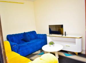 a living room with a blue couch and a table at Cozy Homes in Thika