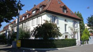 une grande maison blanche avec un toit rouge dans l'établissement B&B Laupenring, Basel, à Bâle