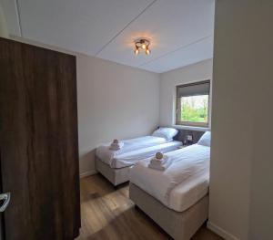 a room with two beds and a window at Kooparc in Giesbeek