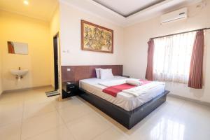 a bedroom with a bed and a sink in it at Samudra Homestay in Kuta