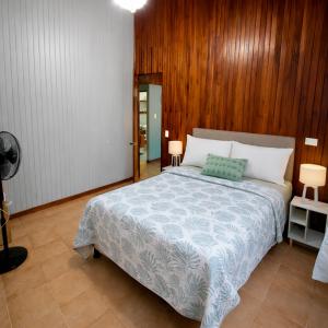 a bedroom with a large bed with a wooden wall at La Casa del Centro in Quesada