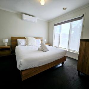a bedroom with a large bed and a large window at Comfort on Mozart in Shepparton