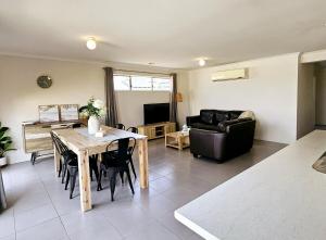 a living room with a table and a couch at Comfort on Mozart in Shepparton +9 photos