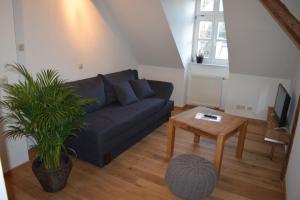 a living room with a blue couch and a table at Stella Apartments am Erfurter Dom in Erfurt