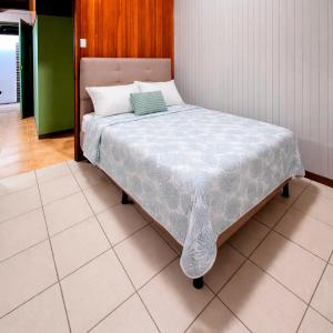 a bed with a blue and white blanket on it at La Casa del Centro in Quesada +9 photos
