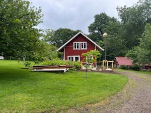 a red barn with a yard with a house at Villa Margit in Tvååker