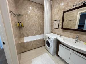 a bathroom with a washing machine and a sink at Parkr Land Elite in Uzhhorod