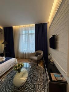 a hotel room with a bed and a chair at Bugu Hotel Bishkek in Bishkek