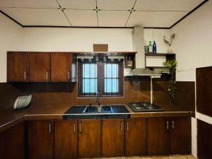 a kitchen with wooden cabinets and a sink and a window at Villa One Hikkaduwa in Hikkaduwa +6 photos
