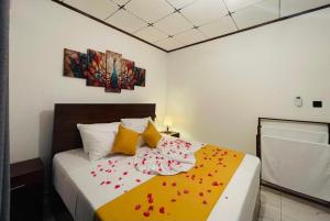 a bedroom with a bed with red flowers on it at Villa One Hikkaduwa in Hikkaduwa