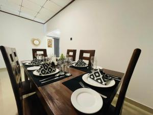 a dining room table with black and white plates on it at Villa One Hikkaduwa in Hikkaduwa