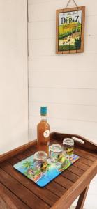 a bottle of honey and two glasses on a wooden table at Superbe T3 avec une grande terrasse et un accès direct aux 2 plages Gros Raisin in Sainte-Luce