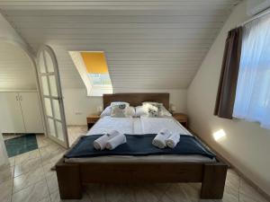 a bedroom with a bed with towels on it at Herczeg Villa in Balatongyörök