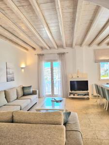 a living room with a couch and a tv at Villa Magenta in Mikonos
