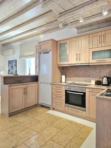 a kitchen with wooden cabinets and a white refrigerator at Villa Magenta in Mikonos