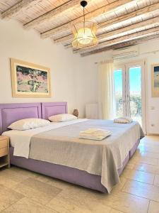 a bedroom with a large bed with a purple headboard at Villa Magenta in Mikonos +31 photos