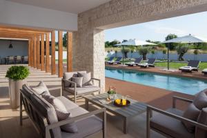 an outdoor patio with lounge chairs and a swimming pool at Villa Royal Green - Happy Rentals in Labin