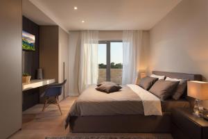 a bedroom with a bed and a desk and a window at Villa Royal Green - Happy Rentals in Labin