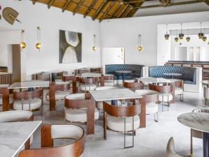 a restaurant with tables and chairs in a room at Bon Hotel Crown Forest in Nsuaem +29 photos