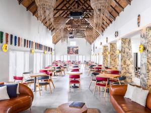 a restaurant with couches and tables and chairs at Bon Hotel Crown Forest in Nsuaem