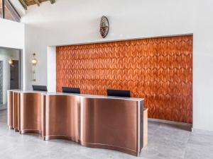 a conference room with a brown wall and chairs at Bon Hotel Crown Forest in Nsuaem