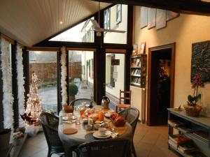 comedor con mesa, sillas y ventana en Le Bien-Aller des Perêts, en Saint-Hubert