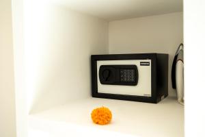 a microwave on a white wall with an orange flower at Villa Lior - 1BR Luxury Hideaway near Nyanyi Beach in Canggu