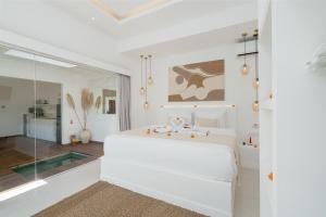 a white bedroom with a large bed and a glass wall at Villa Lior - 1BR Luxury Hideaway near Nyanyi Beach in Canggu +32 photos