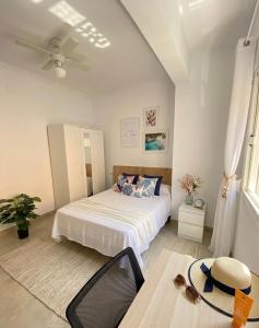 a bedroom with a bed and a ceiling fan at Apartamentos SOL y ARENA in Almería